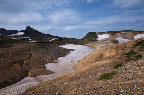 Free Explore a stunning landscape of rocky mountains, snow patches, and clear blue skies. Stock Photo