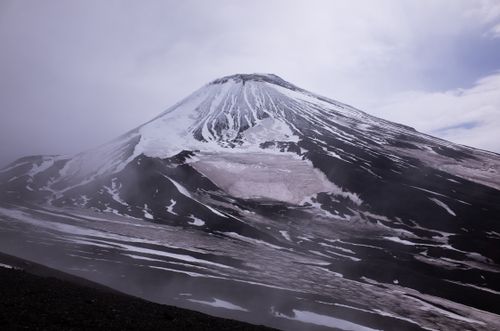 Free Stunning view of a snow-covered volcanic mountain under cloudy skies. Stock Photo