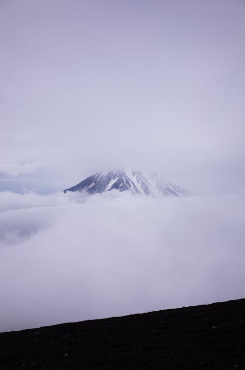 Snow Covered Mountain Under Cloudy Sky