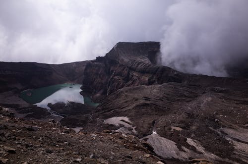 Crater Lake Near Rock Formations on a Foggy Day