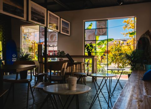 Warm and inviting modern cafe interior in Sochi, featuring natural light and comfortable seating.