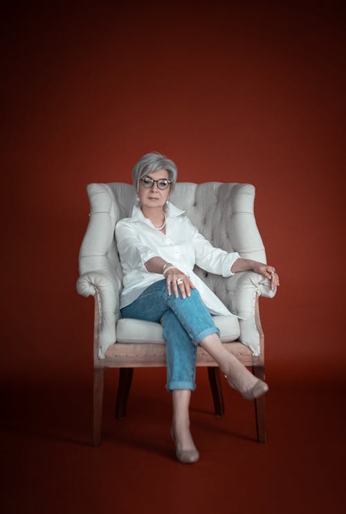 An Elderly Woman in White Long Sleeve Sitting on Armchair