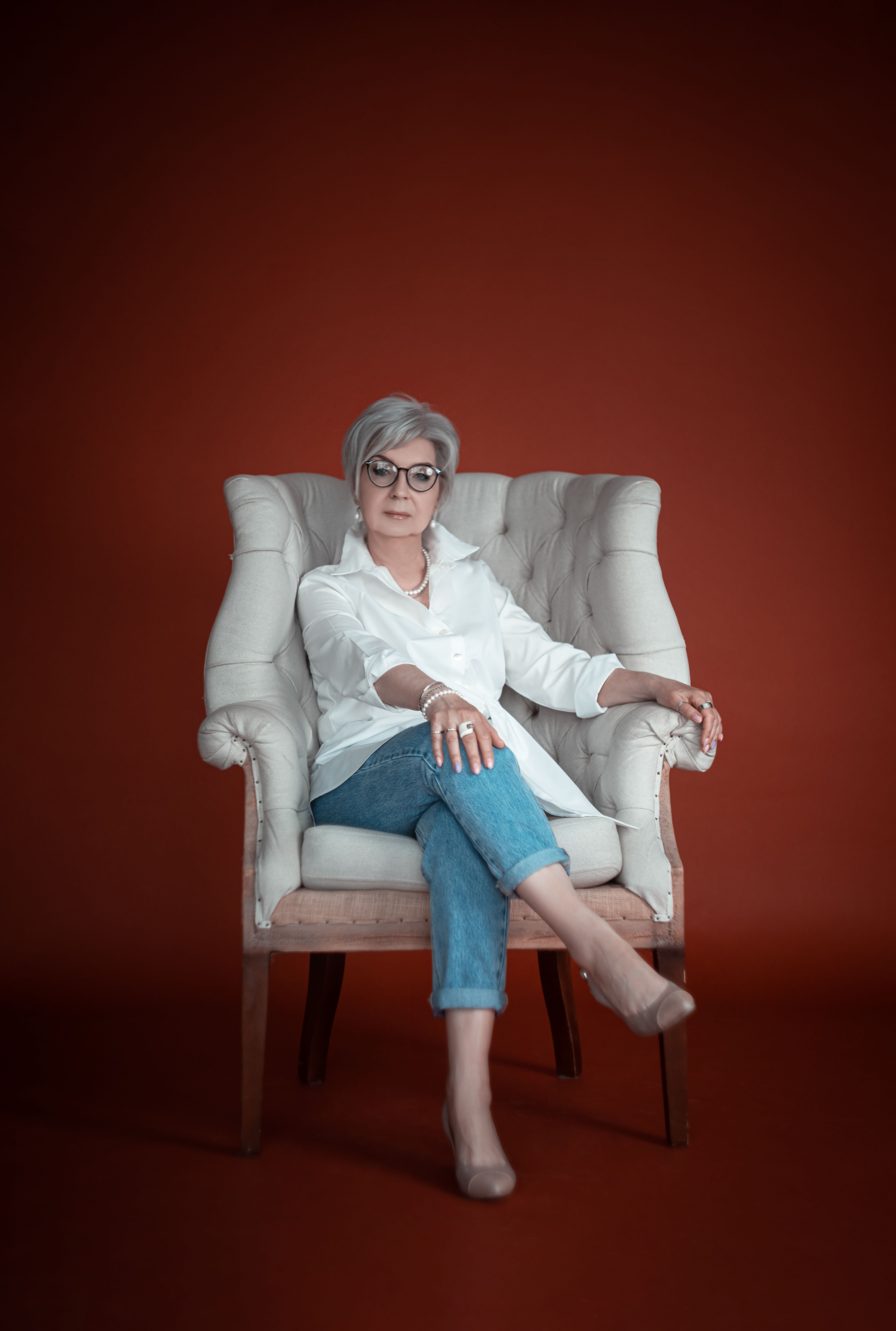 A Woman in Red Long Sleeve Dress Sitting on Black Chair · Free Stock Photo