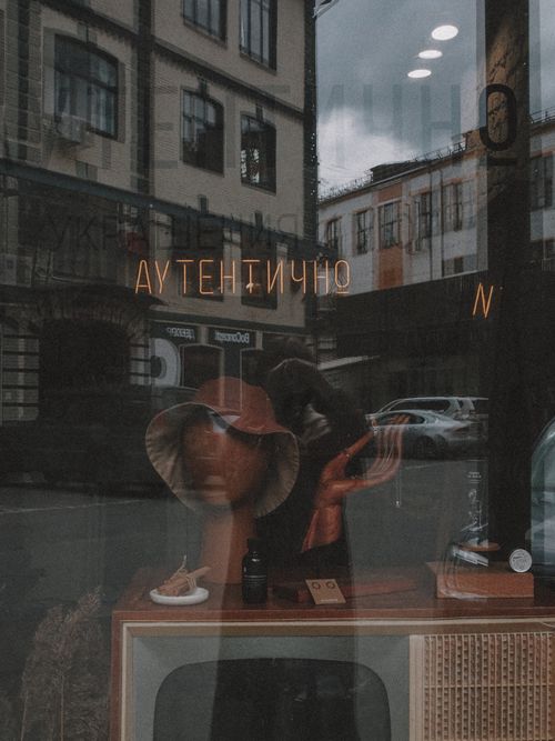 Free A vintage store's window display featuring reflections and antiques in an urban setting. Stock Photo