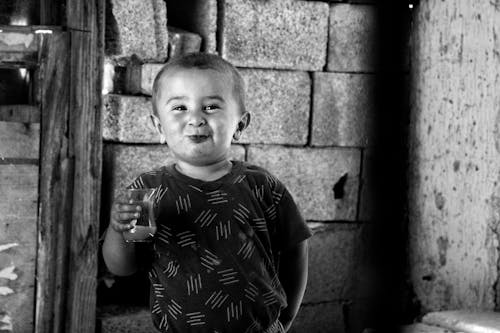 Free Grayscale Photo of a Boy Smiling at the Camera Stock Photo