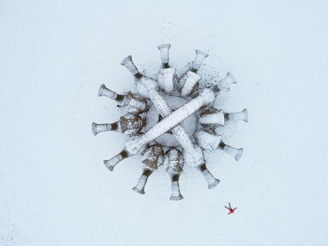 Stunning aerial shot of snow-covered trees in a circular formation with a person in red.