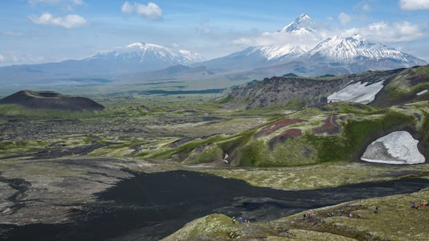 Stunning view of snowy volcanoes with green valleys, perfect for nature exploration.