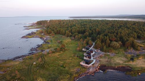 Free A beautiful aerial shot of the coastal landscape in Karelia, Russia, featuring dense forests and serene water. Stock Photo