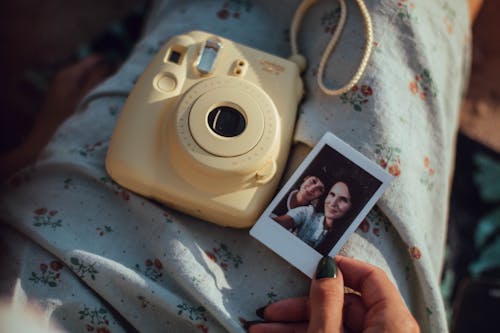 Persona Che Tiene La Foto Della Donna Accanto Alla Fotocamera Istantanea Fujifilm Bianca