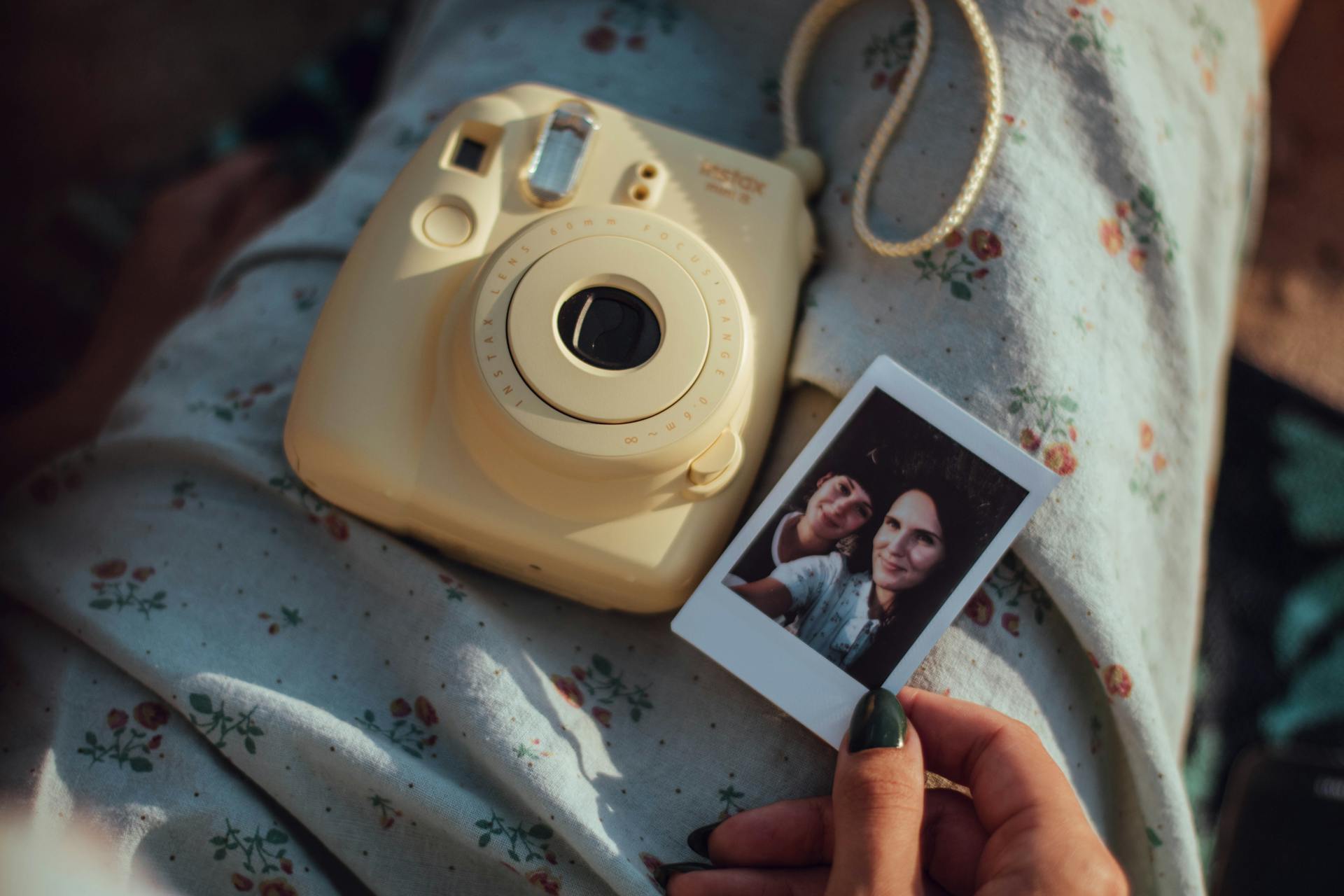 Person Holding Woman's Photo Beside White Fujifilm Instant Camera