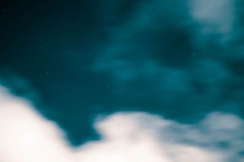 Free Blurred stars peek through soft clouds in an artistic night sky composition, evoking tranquil beauty. Stock Photo