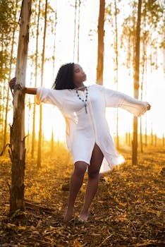 一位身着白色连衣裙的优雅女子，在宁静的森林中享受金色时光