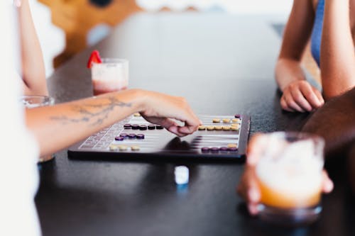 People Playing Board Game on the Black Table Top