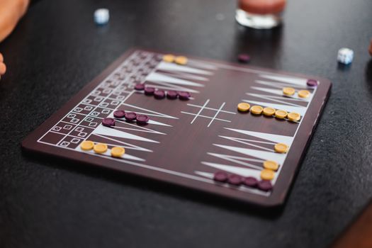 An overhead view of a backgammon game in progress with dice and checker pieces.
