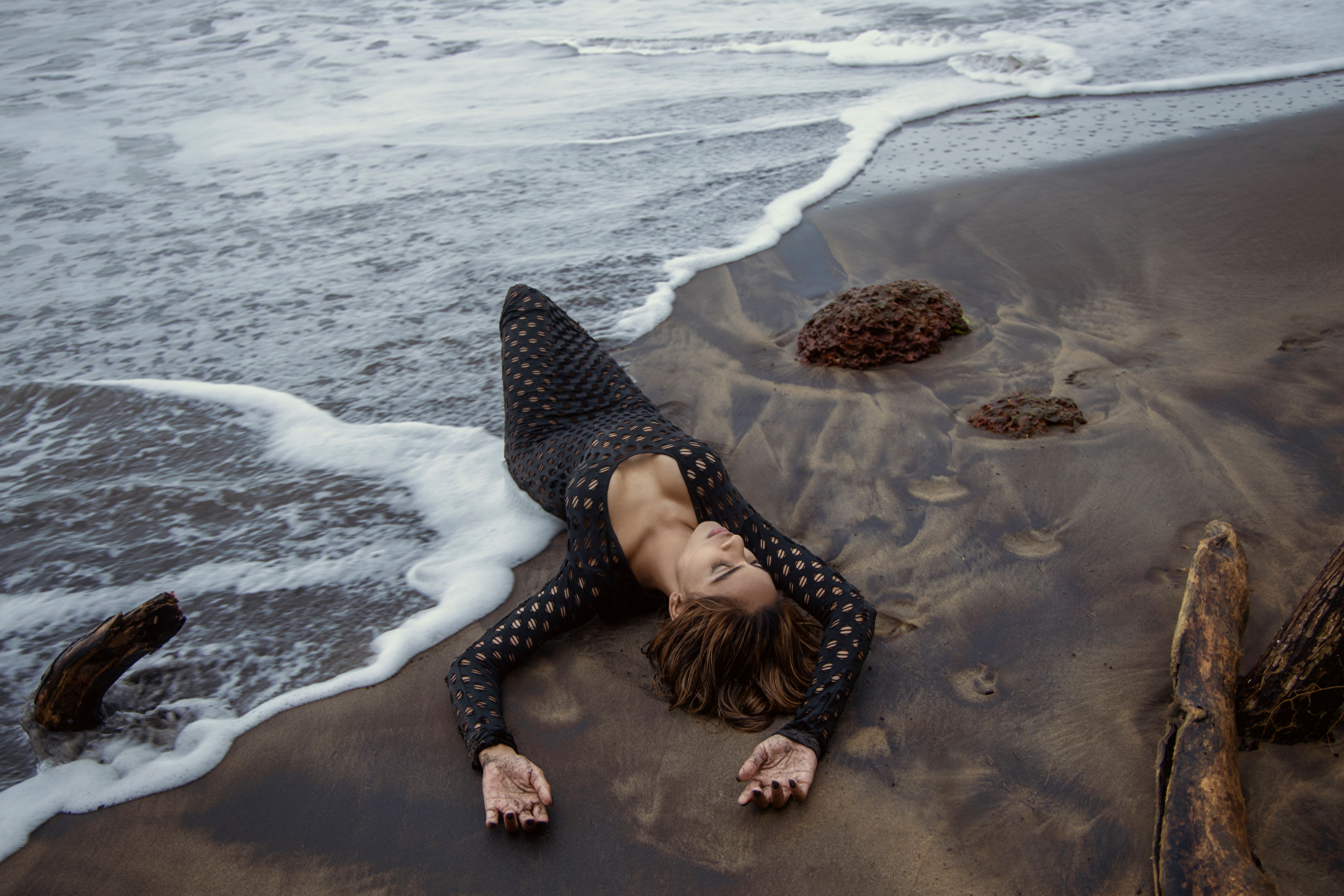 Woman i Black Dress Lying Down on the Seashore · Free Stock Photo
