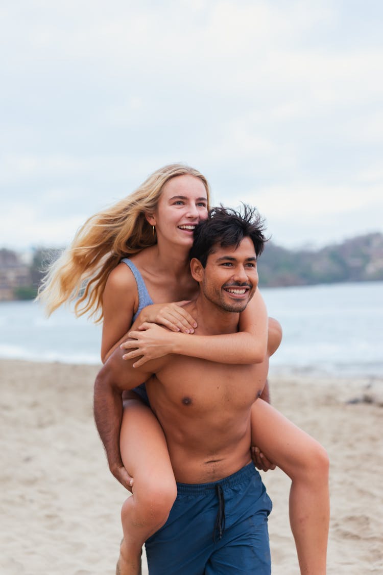 Topless Man Carrying A Woman On His Back