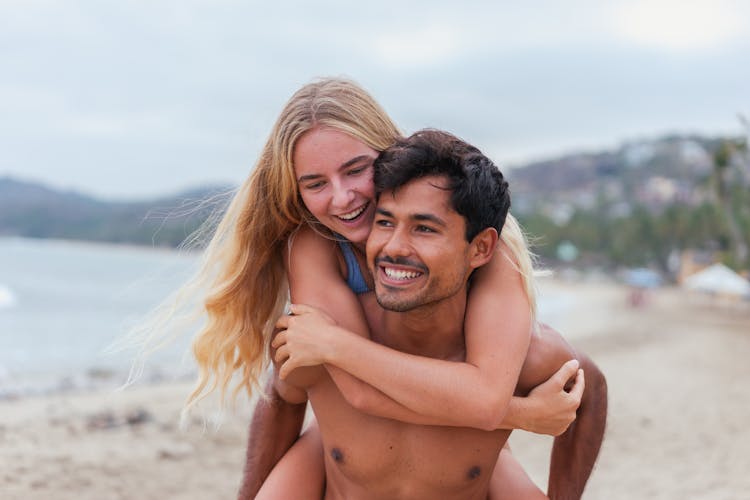 Topless Man Carrying A Woman On His Back