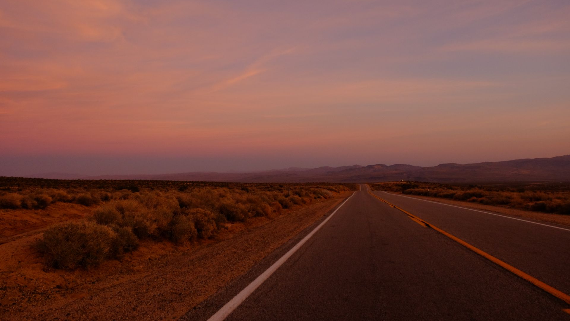 An empty desert road at dusk