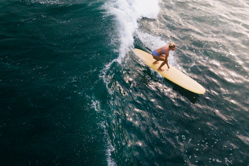 Free High-Angle Shot of a Woman Surfing on the Waves Stock Photo