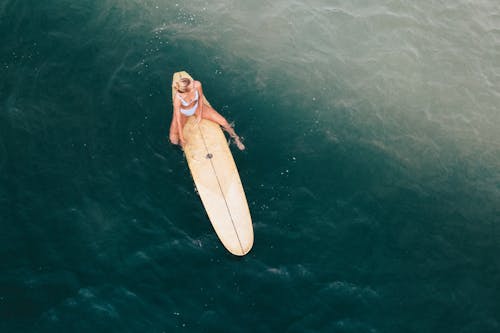 A Woman Sitting on a Surfboard 