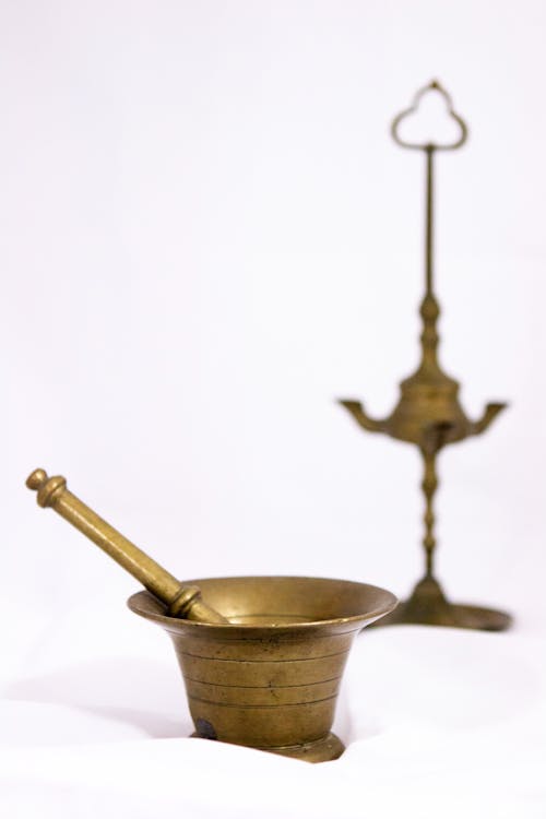 Gold Mortar and Pestle on White Surface