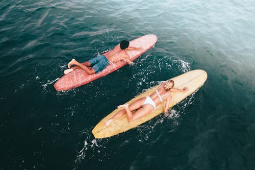 Aerial Photography of Man and Woman Surfing