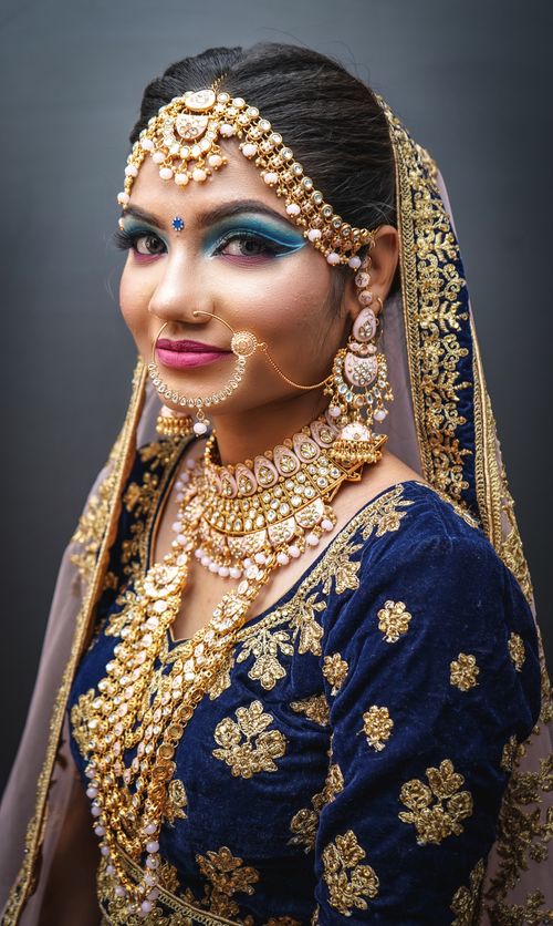 Free Portrait of a bride in traditional Indian attire with ornate jewelry and a vibrant dress. Stock Photo