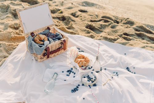 Free A serene beach picnic with fresh croissants and blueberries. Stock Photo