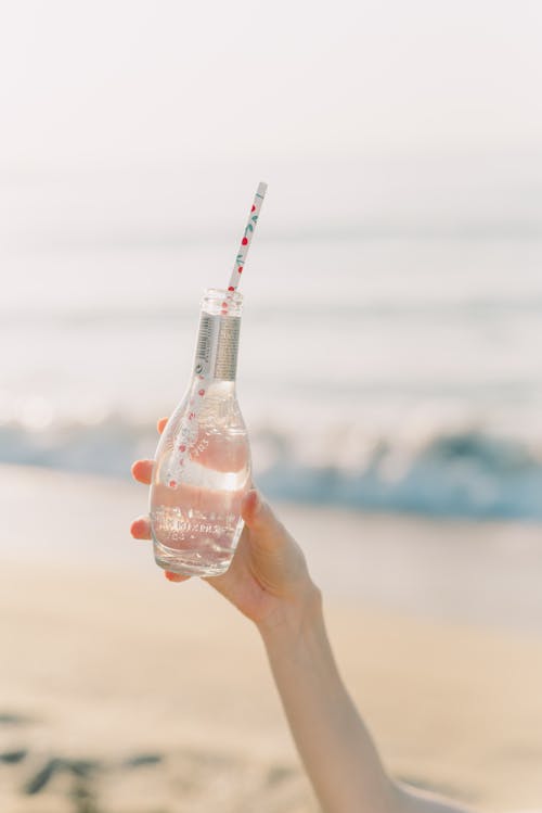 Free A Person Holding a Bottle with Straw Stock Photo