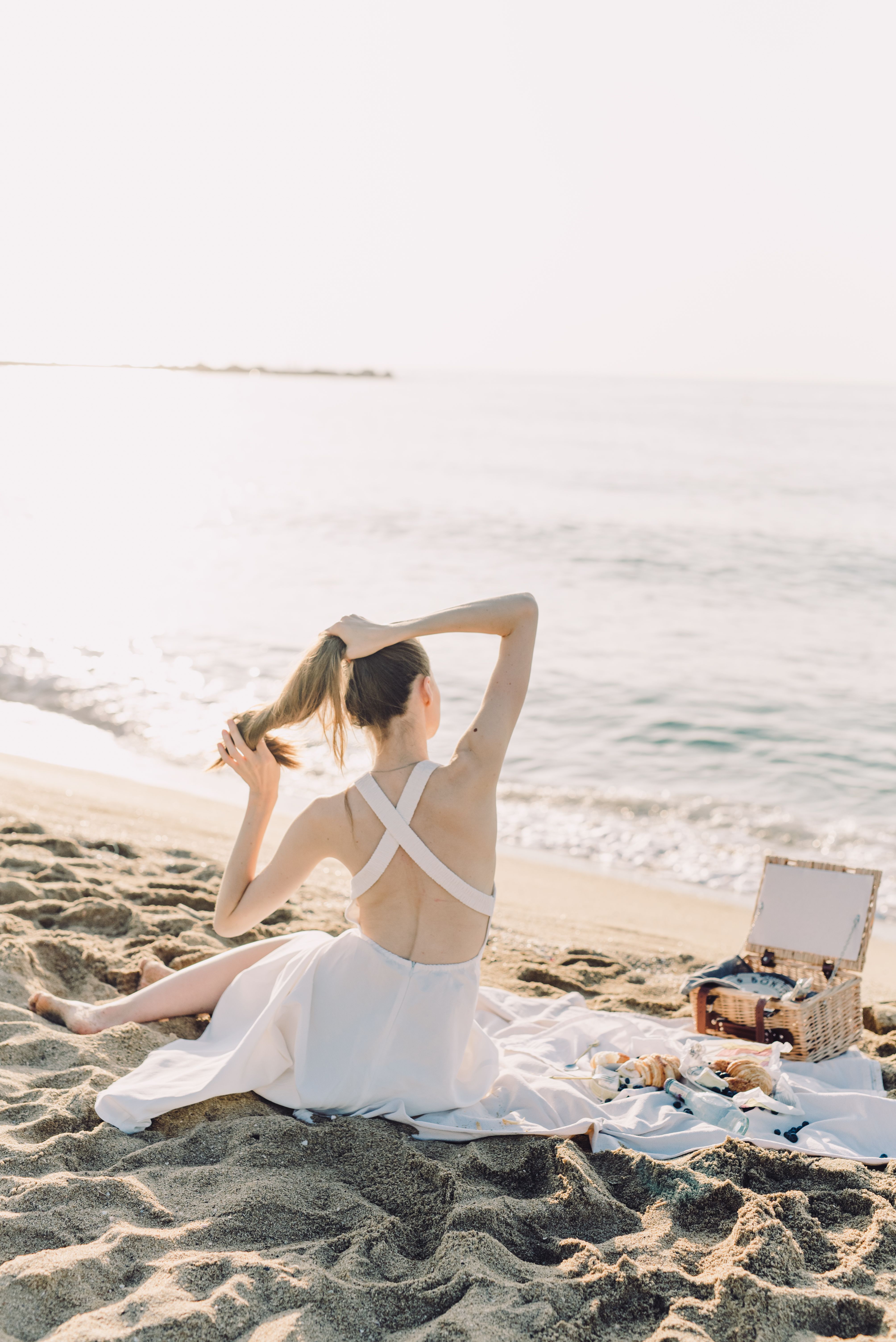 Back View of Woman Sitting on Beach on Sea Shore · Free Stock Photo