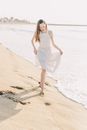 Woman in White Sleeveless Dress Standing on Beach