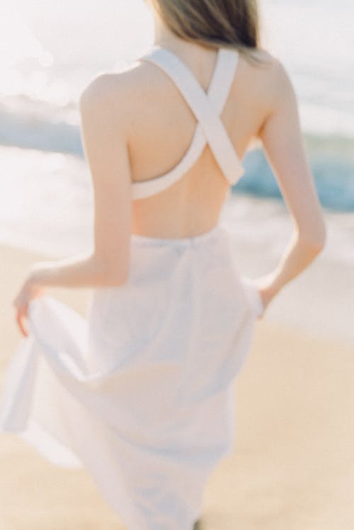 Back View of a Woman Wearing White Dress on the Beach