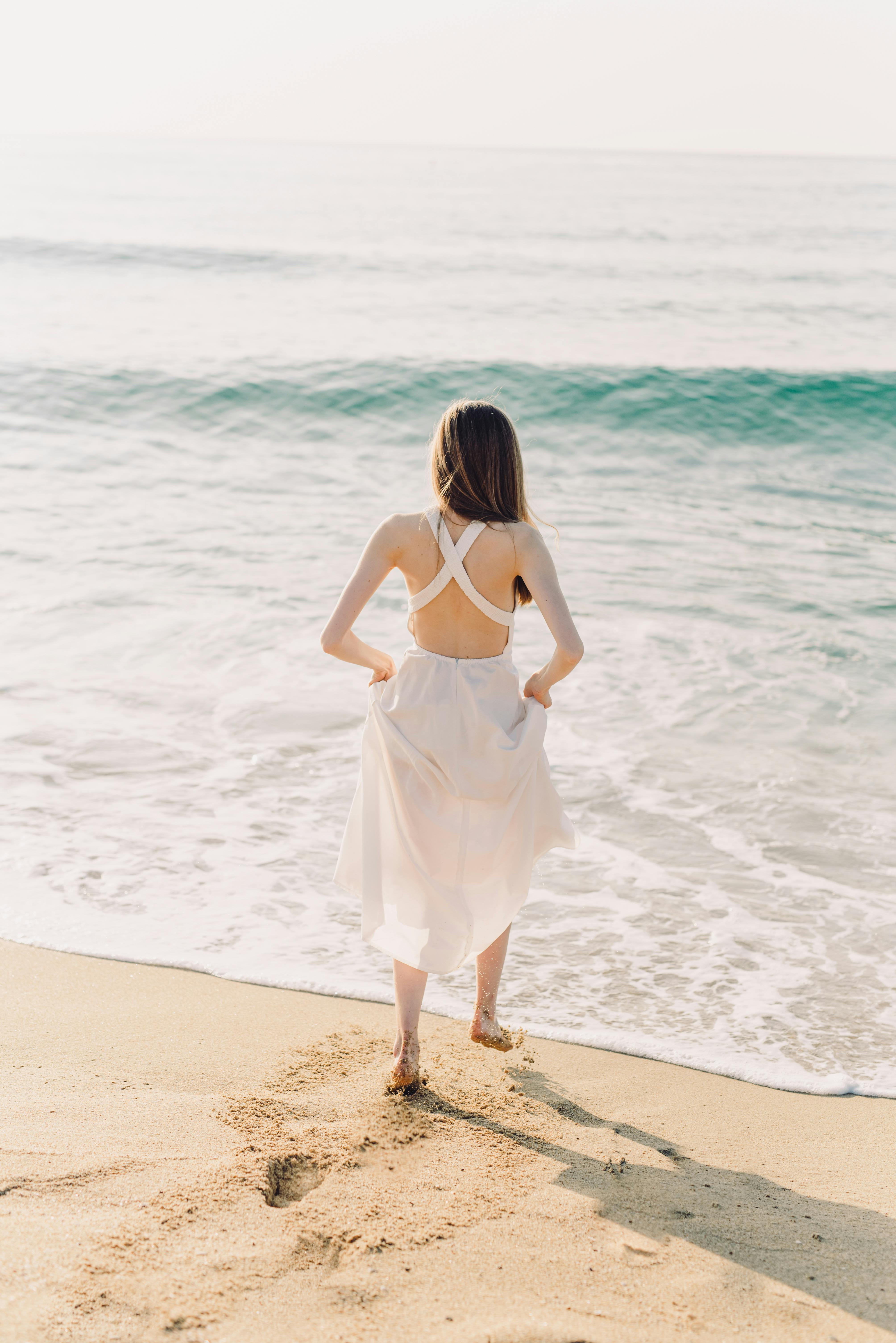 Woman Standing on Crashing Waves on the Shore · Free Stock Photo