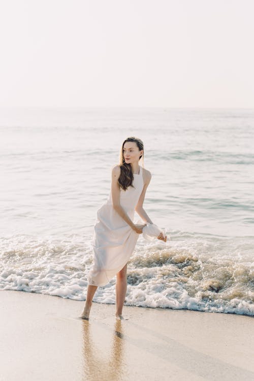 Безкоштовне стокове фото на тему «берег, біла сукня, вертикальні постріл»