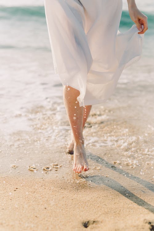 Free Female Barefoot Walking on Beach Stock Photo