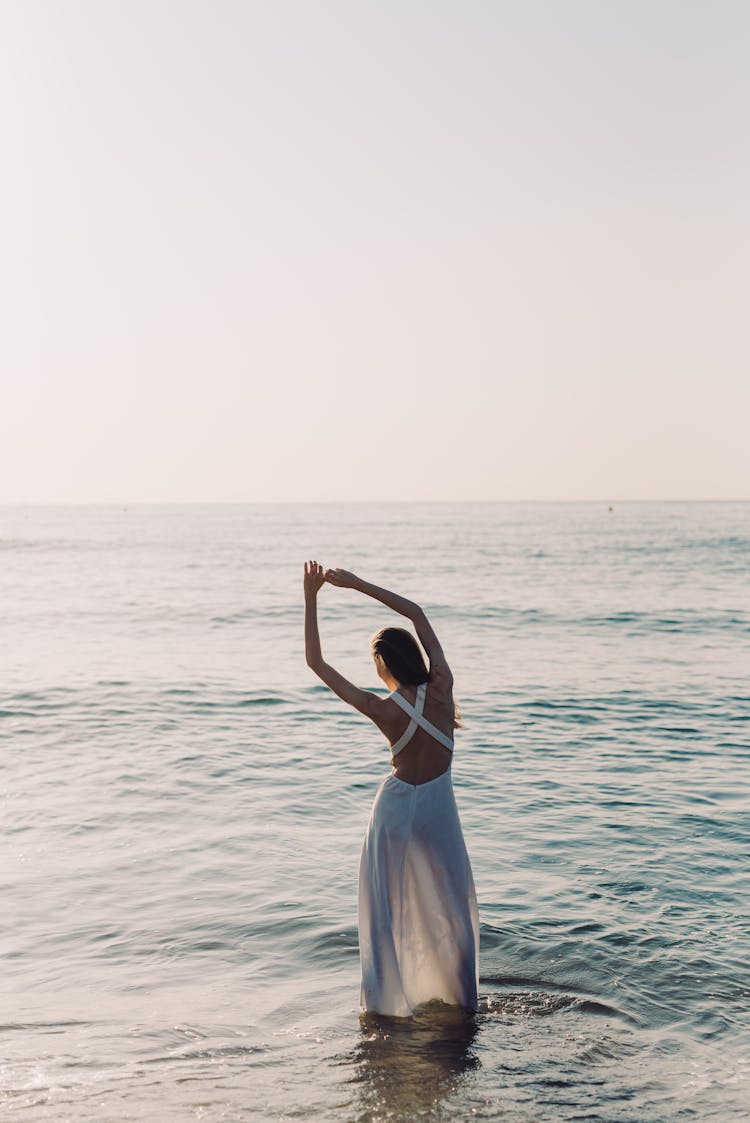 Back View Of A Woman In White Dress Posing On The Beach