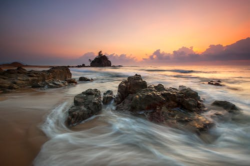 Piedra En La Orilla Del Mar Durante La Puesta De Sol