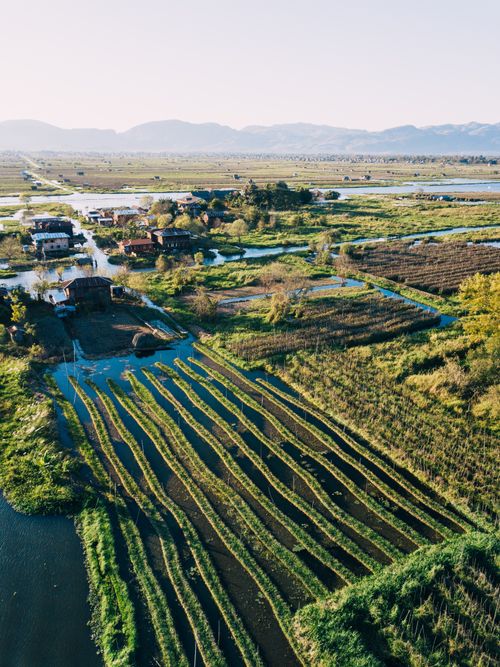 Free Aerial view of Myanmar's countryside with fields, farms, and water channels. Stock Photo
