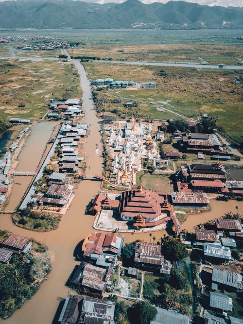Free A beautiful aerial shot showing a rural community with temples near water channels in lush countryside. Stock Photo