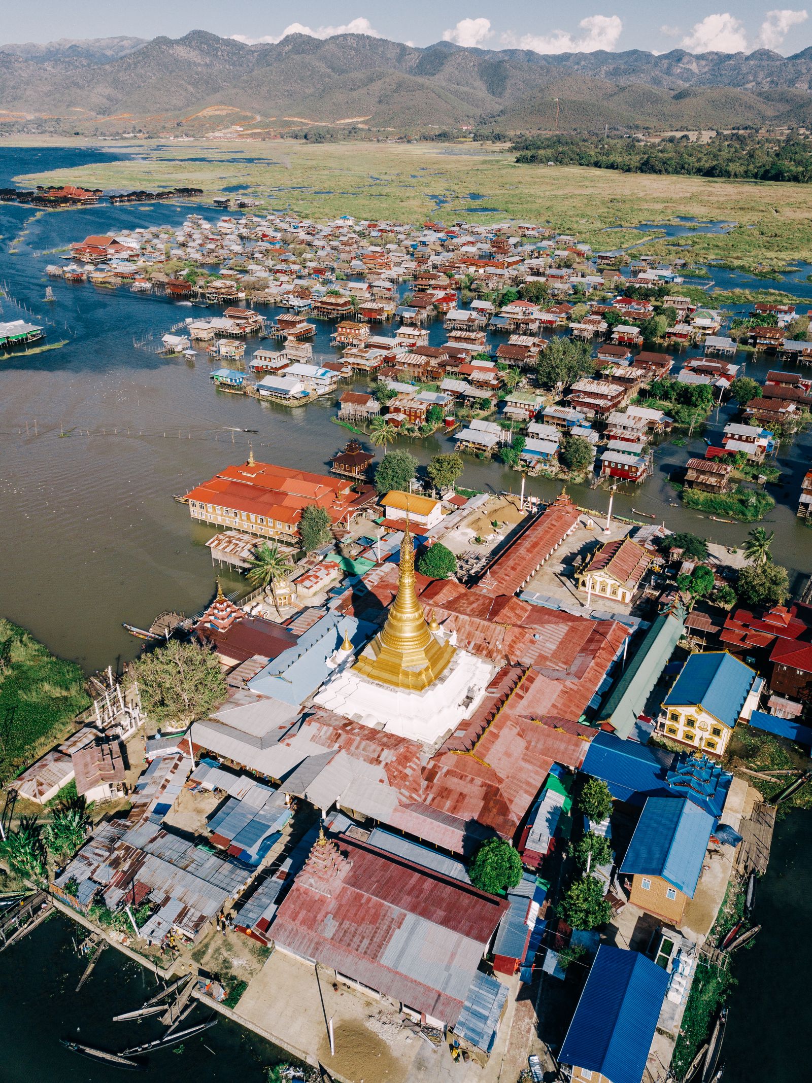 Aerial view of a floating village and golden pagoda on Inle Lake in Shan State, Myanmar