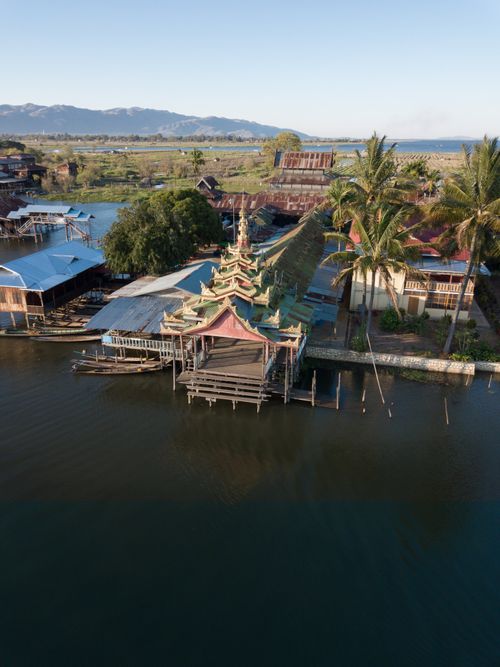 Free Picturesque aerial shot of a traditional temple on the water in Shan State, Myanmar, surrounded by scenic landscape. Stock Photo