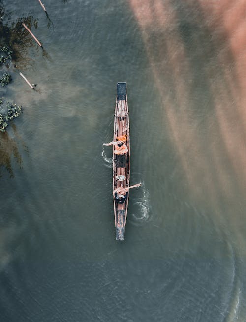 Aerial Photography of Two People Riding a Wooden Boat on the Lake