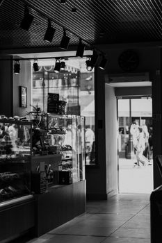 Monochrome image of a cafe interior in Moscow with people outside.