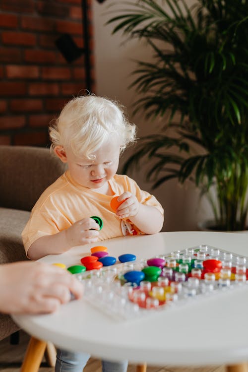 Child Playing with Round Colored Objects