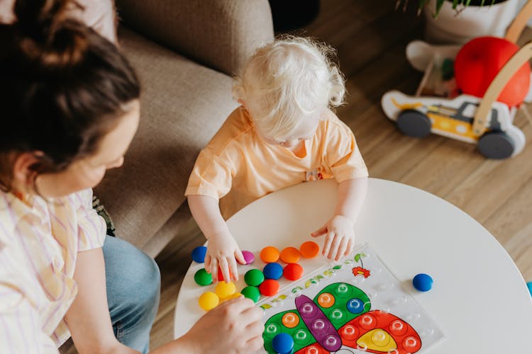 A Toddler Playing With Developmental Toys