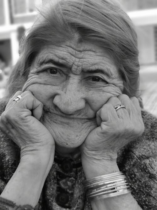 Elderly Woman with Hands on Cheeks