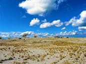 在点缀着蓬松云朵的蓝天下，探索广阔的干旱地形