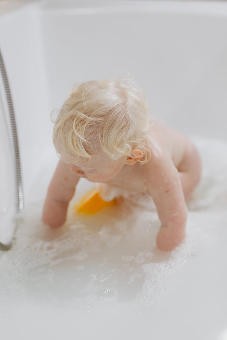 Photo Of A Child With Blond Hair Taking A Bath