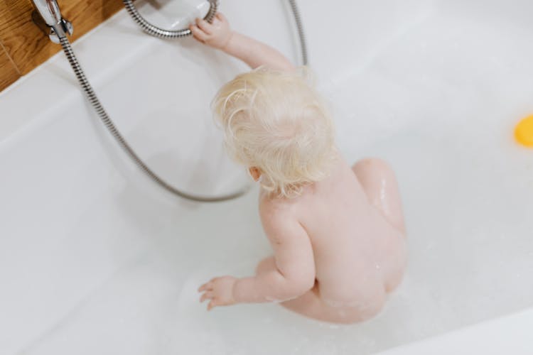 Baby Girl Sitting In Bathtub