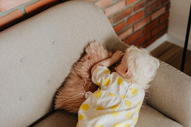 A Toddler Sleeping On The Couch